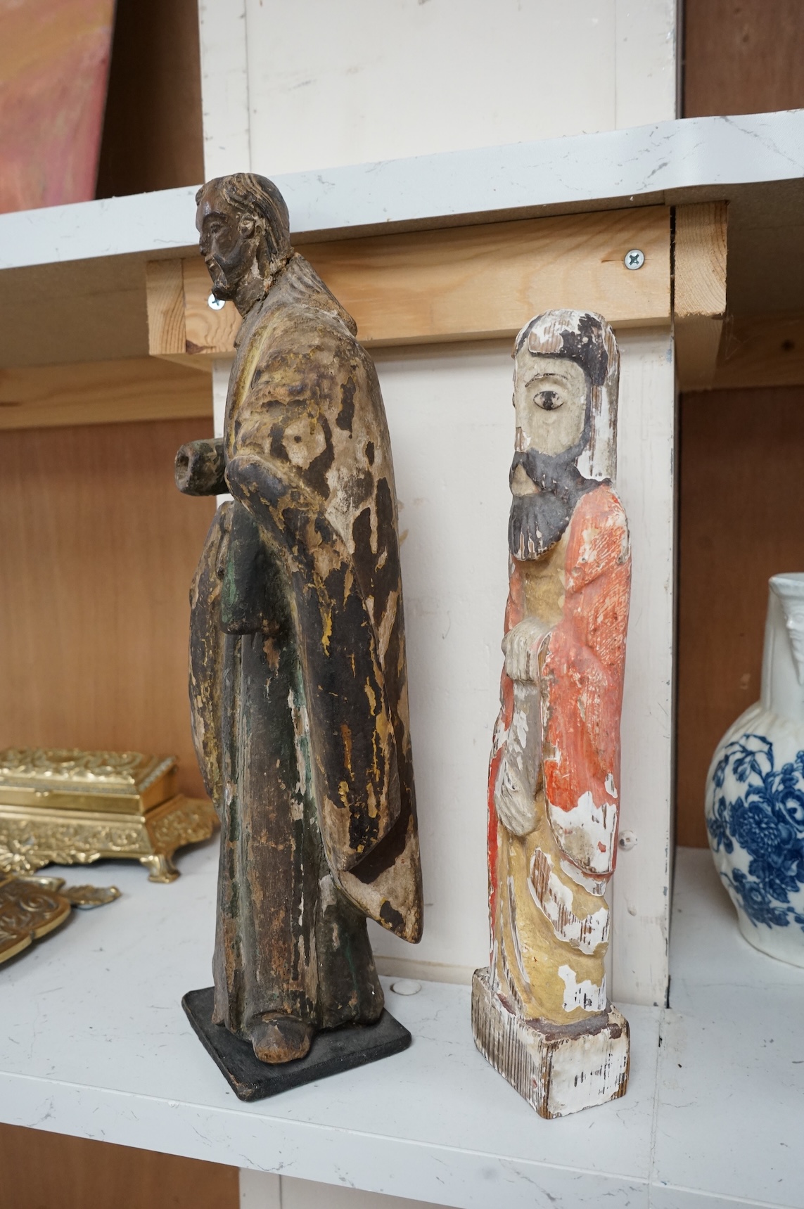 An antique carved wood figure of a Saint, traces of old paint and another figure, largest 36cm high (2)